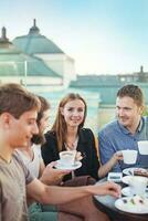 une groupe de gens séance à une table avec café photo