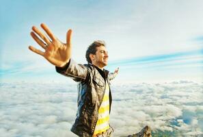 une homme permanent sur Haut de une Montagne avec le sien bras tendu photo