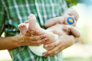 une homme en portant une bébé dans le sien bras photo