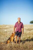 une homme et le sien chien dans une champ photo