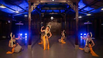 une groupe de sundanais danseurs dans Jaune costumes Danse une traditionnel Danse dans de face de une bleu lumière photo