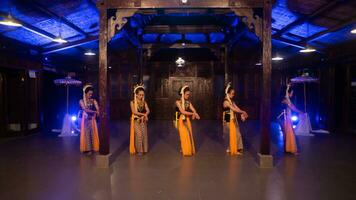 une groupe de sundanais danseurs dans Jaune costumes Danse une traditionnel Danse dans de face de une bleu lumière photo