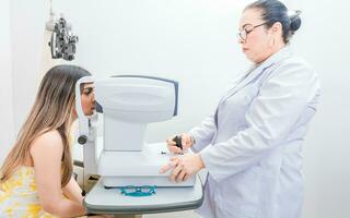 optométriste vérification le vue de une patient avec un autoréfracteur. oculiste Faire œil examen à femelle patient photo