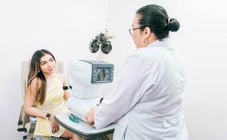 optométriste avec femelle patient dans le autoréfracteur. femme patient ayant consultation avec optométriste dans Bureau photo