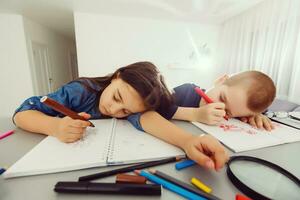 peu garçon en train de dormir sur bureau avec fille dans Contexte à salle de cours photo