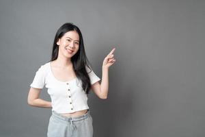 femme asiatique avec le visage souriant et la main présentant sur le côté photo