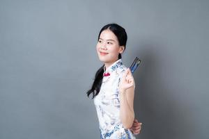 une femme asiatique porte une robe traditionnelle chinoise avec une main tenant une carte de crédit photo