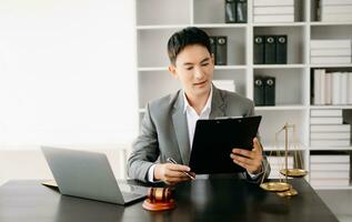 Justice et loi concept .asiatique Masculin juge dans une salle d'audience sur table et conseiller travail dans bureau. photo