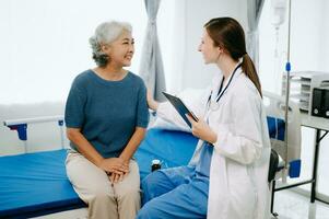 caucasien médecin souriant prendre se soucier de une Jeune patient dans hôpital. amical infirmière ou thérapeutique traiter client professionnel médical un service concept. photo