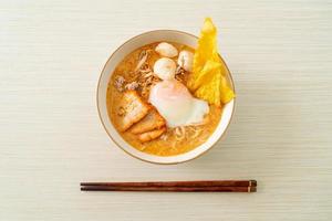 nouilles de vermicelles de riz avec boulette de viande, porc rôti et œuf dans une soupe épicée photo