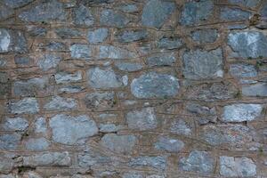 pierre des murs sont fabriqué de énorme grand briques avec béton et ciment. solide bâtiment structure. texturé Contexte avec fermer détails photo