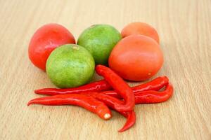 tomate, citron et rouge le Chili sur en bois Contexte photo