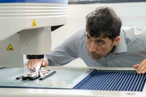 La technologie concept une homme au travail ingénieur panneau planche ic électronique microscope à travail avec une puce électronique. électronique recherche laboratoire. fabrication de puces. équipement pour essai photo