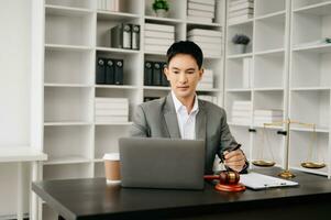 Justice et loi concept .asiatique Masculin juge dans une salle d'audience sur table et conseiller travail dans bureau. photo