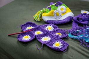 crochet accessoires avec Koche, en utilisant multicolore fils, artisanat, sur vert velours. photo