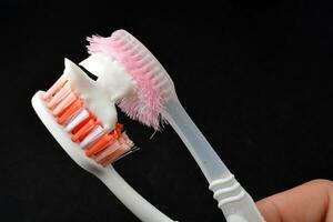 blanc dentifrice sur une brosse à dents. noir Contexte photo