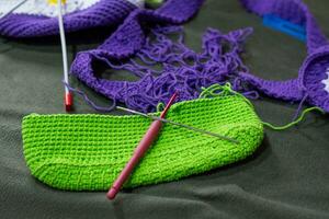 crochet accessoires avec Koche, en utilisant multicolore fils, artisanat, sur vert velours. photo