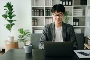 Jeune affaires homme exécutif directeur à la recherche à portable en train de regarder en ligne séminaire en ligne formation ou ayant virtuel réunion vidéo conférence Faire marché recherche travail dans bureau. photo