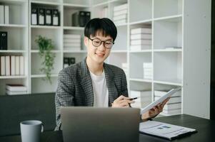 Jeune affaires homme exécutif directeur à la recherche à portable en train de regarder en ligne séminaire en ligne formation ou ayant virtuel réunion vidéo conférence Faire marché recherche travail dans bureau. photo