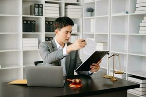 Justice et loi concept .asiatique Masculin juge dans une salle d'audience sur table et conseiller travail dans bureau. photo