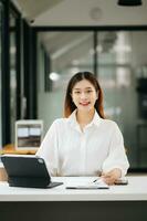 réussi asiatique femme d'affaires en cours d'analyse la finance sur tablette et portable à moderne Bureau bureau impôt, rapport, comptabilité, statistiques, et analytique recherche concept photo