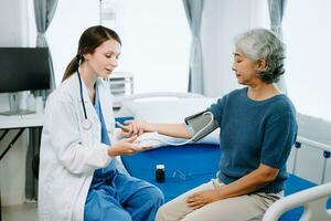 femme médecin et patient discuter quelque chose tandis que séance sur examen lit dans moderne clinique ou hôpital . médicament et santé se soucier concept. photo