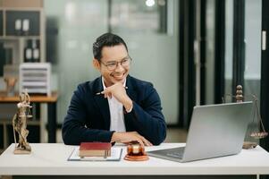 Justice et loi concept .asiatique Masculin juge dans une salle d'audience sur table et conseiller travail dans moderne bureau. photo