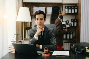 asiatique avocat homme travail avec une portable et tablette dans une loi bureau. légal et légal un service concept. à la recherche à caméra dans moderne Bureau photo