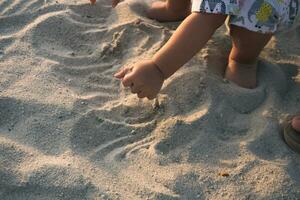 proche en haut de enfant mains creusement sur le plage le sable photo