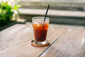 transparent verre de la glace noir café ou americano sur en bois table avec sélectif concentrer dans café restaurant photo