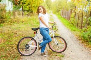 jeune femme à vélo dans le parc de la ville d'été à l'extérieur. personnes actives. fille hipster se détendre et faire du vélo. faire du vélo au travail le jour de l'été. concept de mode de vie vélo et écologie. photo