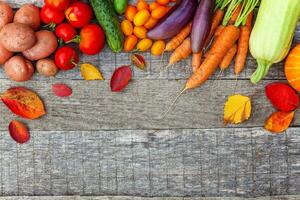 assortiment de différents légumes biologiques frais sur fond en bois de style campagnard. concept de régime végétarien végétalien d'aliments sains. jardin local produit de la nourriture propre. vue de dessus du cadre espace de copie à plat. photo