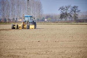 un tracteur agricole travaille un champ fraîchement labouré photo