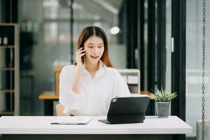 réussi asiatique femme d'affaires en cours d'analyse la finance sur tablette et portable à moderne Bureau bureau impôt, rapport, comptabilité, statistiques, et analytique recherche concept photo