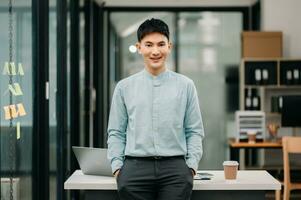 Jeune attrayant asiatique Masculin Bureau ouvrier affaires souriant à caméra dans Bureau photo
