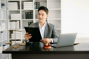 Justice et loi concept .asiatique Masculin juge dans une salle d'audience sur table et conseiller travail dans bureau. photo