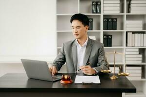 Justice et loi concept .asiatique Masculin juge dans une salle d'audience sur table et conseiller travail dans bureau. photo