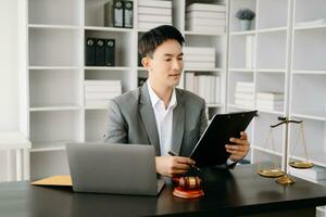 Justice et loi concept .asiatique Masculin juge dans une salle d'audience sur table et conseiller travail dans bureau. photo