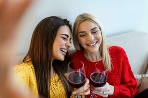 excité copains prise selfie et en riant. intérieur coup de deux émotif caucasien filles. deux adulte femme fabrication selfies avec marrant visages. deux femelle copains prise une selfie photo