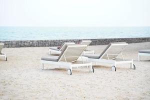 chaises longues blanches sur la plage. fond d'été de vacances de vacances. photo