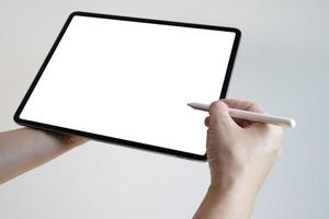 main à l'aide d'un écran blanc tactile de stylet de tablette numérique. mains tenant et écrivant sur tablette numérique. photo