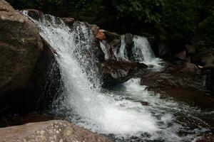 fermer vue de clair l'eau en cascade vers le bas rivière rochers photo