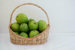 goyave fruit dans panier sur blanc Contexte photo