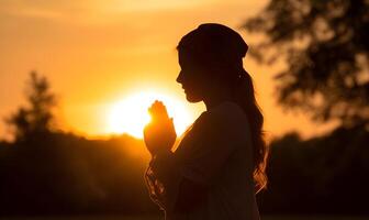 silhouette de Christian femme prier culte à le coucher du soleil photo