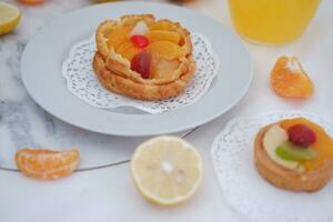 fruit Tarte sur une blanc assiette avec citrons et mandarines photo