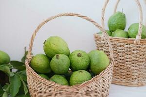 goyave fruit dans panier sur blanc Contexte photo