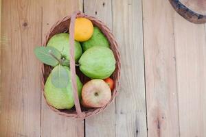 panier de pommes, des oranges et goyave sur une en bois tableau, Stock photo
