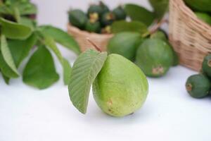 Frais goyave fruit dans une panier sur blanc Contexte. sélectif se concentrer. photo