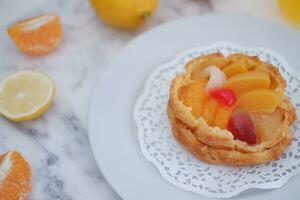 fruit Tarte sur une blanc assiette avec citrons et mandarines photo