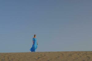 femme dans bleu robe contre le ciel photo